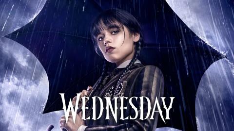 Wednesday Addams holding an umbrella with the title card of WEDNESDAY from Netflix in the front in white letters