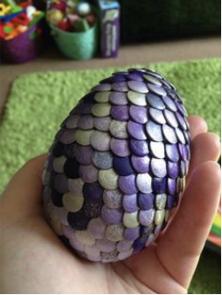 Dragon Egg with purple and silver scales held in the palm of someone's hand.