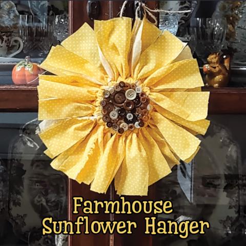 Image of the craft featuring yellow strips of cloth in a circle with a brown center made up of brown buttons. All made to look like a sunflower.