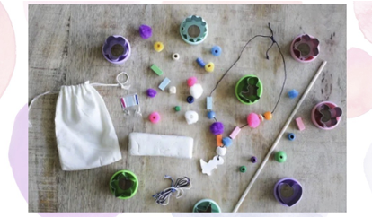 Small cloth bag with beads and other colored objects scattered around it.