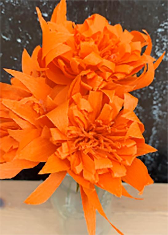 Image of the craft featuring orange mums made from crepe paper.