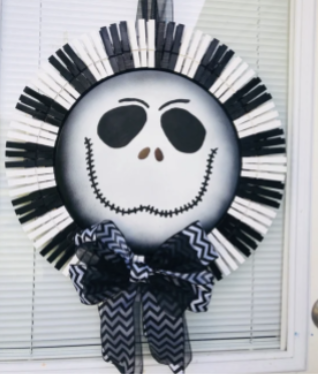 Jack Skellington wreath featuring black and white clothespins on the outside and a striped ribbon at the base