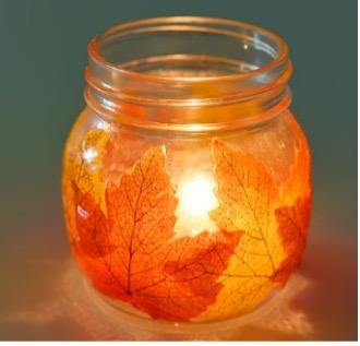 mason jar decorated with leaves and lit with candle 