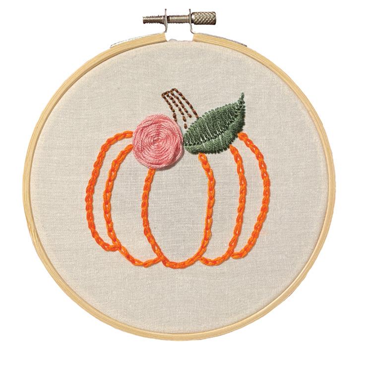 Image of a circle wooden embroidery hoop with an embroidered pumpkin on the fabric.