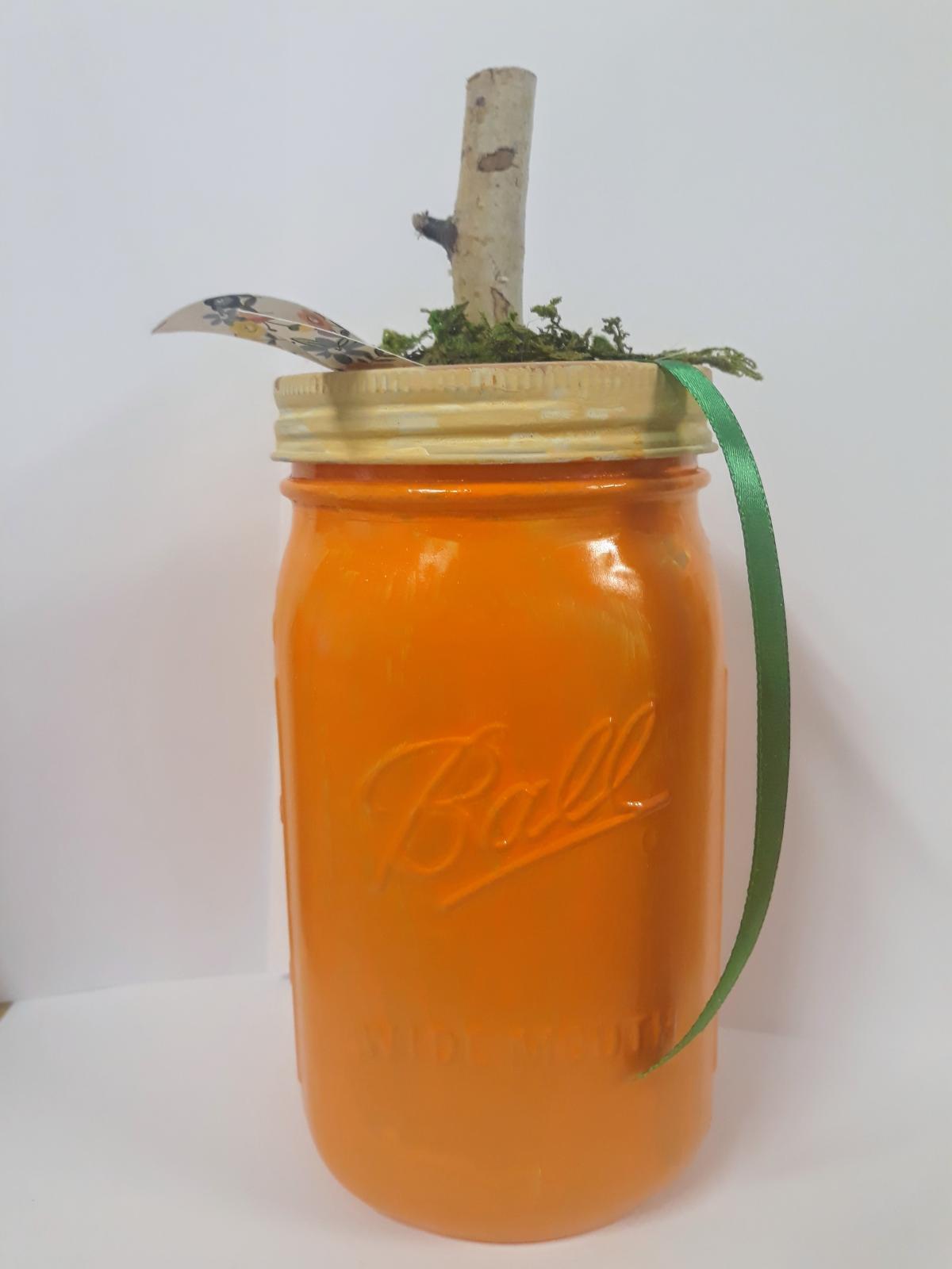 Image of the craft, a painted mason jar with a stem dressed to look like a pumpkin.